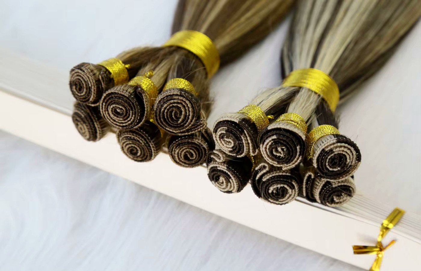 Wholesale hand tied weft Virgin human hair sheets compared for thin single track and stock color consistency