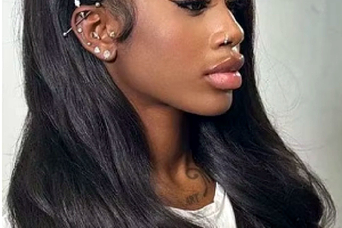 Salon model wearing long body-wave black clip-in human hair extensions with seamless blend